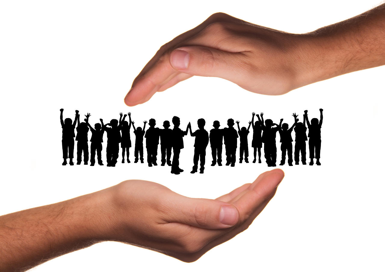 Hands protecting group of silhouette children